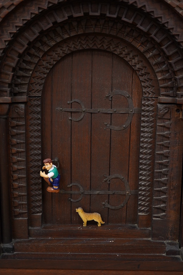 A carved oak firescreen in form of a Norman Romanesque church door and frontage Height 69cm. Width 62cm. Condition - fair
